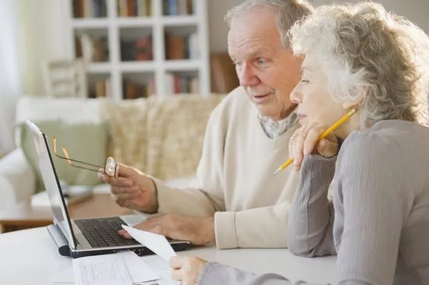 Senior couple going over bills with laptop