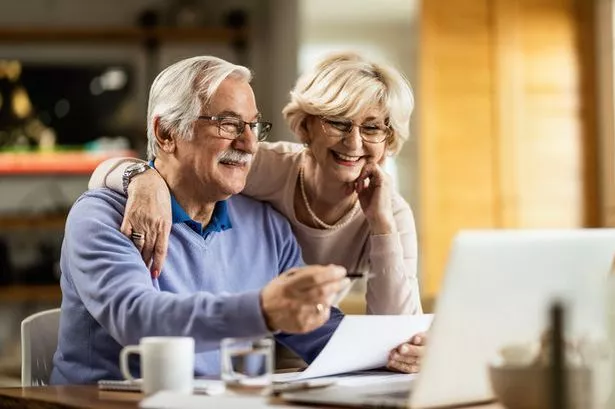 Happy mature couple using laptop