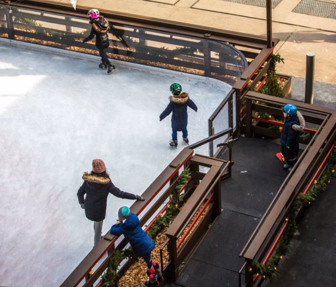 Children skating on a small outdoor ice rink