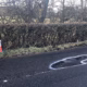 A pothole marked out in white paint beside a traffic cone