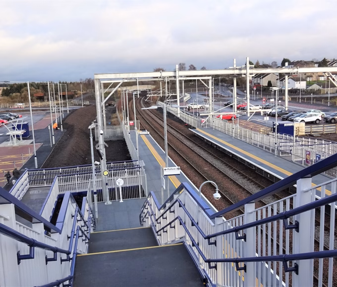 Robroyston station platforms with the station car park and houses behind